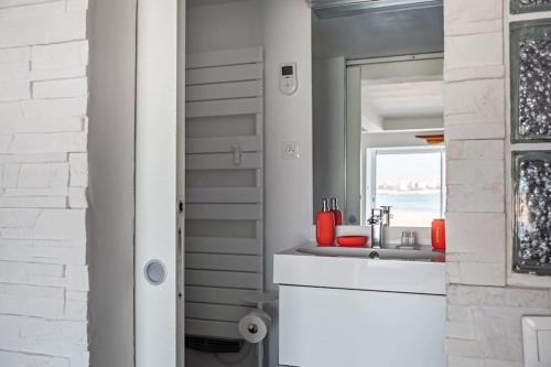 uma casa de banho com um lavatório e uma janela em Cabanon avec terrasse - bord de plage - Le Cabanon 12 em Marselha