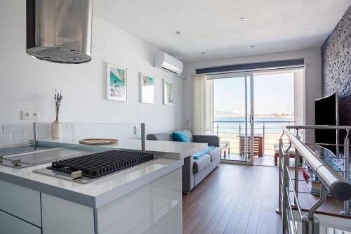 uma cozinha com um fogão e uma sala de estar em Cabanon avec terrasse - bord de plage - Le Cabanon 12 em Marselha