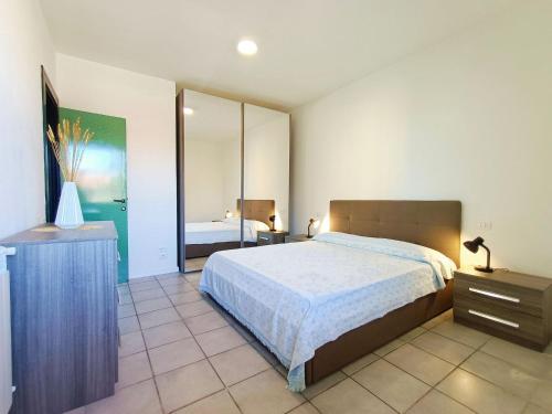 1 dormitorio con 1 cama grande y espejo en Large Panoramic Terrace 2-bedroom in Viareggio sleeps 4, en Viareggio