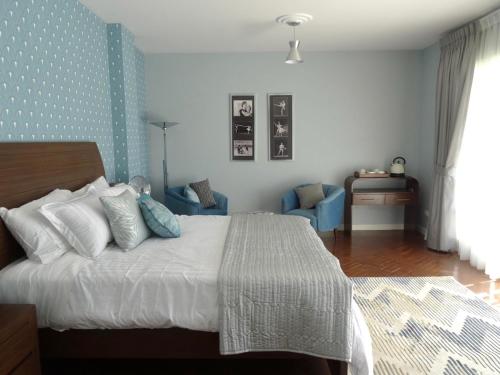 ein Schlafzimmer mit einem Bett und einer blauen Wand in der Unterkunft Casa Deco Hotel Boutique in Cochabamba