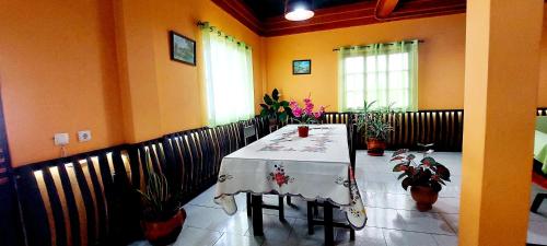 een eetkamer met een tafel en een aantal planten bij Apartamentos Villa in Ponta do Sol