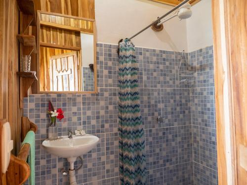 a blue tiled bathroom with a sink and a shower at Finca Colibri Ecolodges en Pleine Nature ferry Playa Najanjo Costa Rica in Cabo Blanco