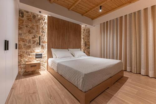 a bedroom with a bed and a stone wall at A&N Athens Luxury Apartments - Akadimou in Athens