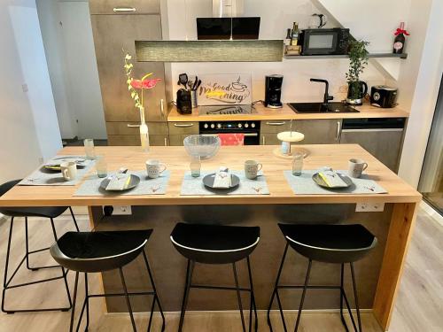 uma cozinha com uma mesa de madeira com quatro bancos em Appartements BERGTRAUM em Gröbming