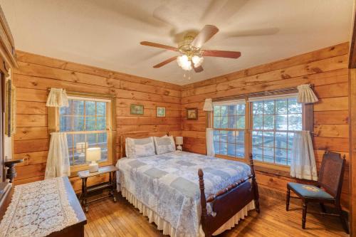 1 dormitorio con 1 cama y ventilador de techo en Lakefront Blairsville Cabin with Deck and Dock!, en Blairsville