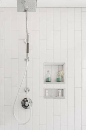 a shower in a white tiled bathroom at This property is unlisted in Cincinnati