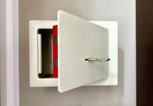 um interruptor branco com uma caixa vermelha na parede em Top Apartment em Beccacivetta