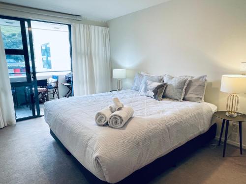 a bedroom with a large bed with towels on it at Oceanside Apartment in Mount Maunganui