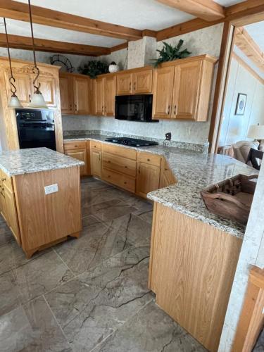 a kitchen with wooden cabinets and granite counter tops at Swan Lake Resort in Galloway