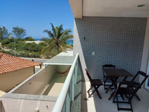 balcón con mesa, sillas y vistas al océano en Ed. Le Bon Vivant, en Arraial do Cabo