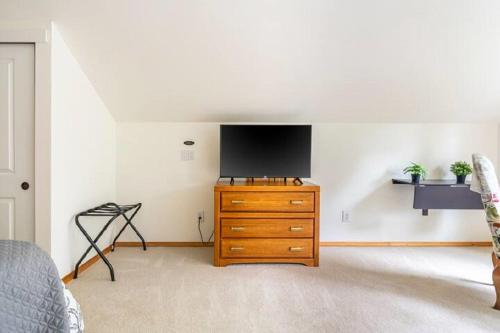 a bedroom with a dresser with a television on a wall at Private Waterfront Retreat near downtown Auburn in Auburn