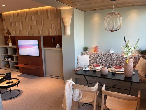 un salon avec une table et un canapé dans l'établissement LUXURIOUS APARTMENT ON THE BEACH, à Saint-Laurent-du-Var