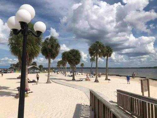 a street light on a sandy beach with palm trees at Modern 3BR Home, Saltwater Pool, Fenced Yard in Spring Hill