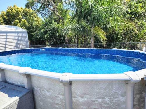 a large swimming pool with a white rail around it at Modern 3BR Home, Saltwater Pool, Fenced Yard in Spring Hill