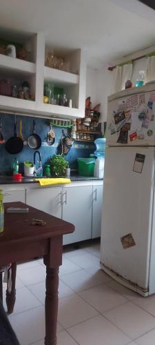 a kitchen with a refrigerator and a table in it at LA CASA DE CLAU in Sarandí