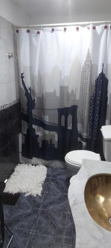 a bathroom with a toilet and a city shower curtain at LA CASA DE CLAU in Sarandí