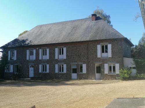 a large brick house with white windows on a dirt field at Au regard des biches in Sovet