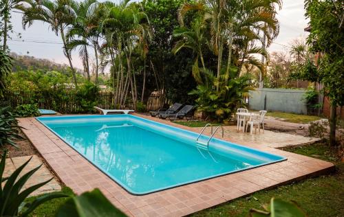 a swimming pool in a yard with a table and chairs at Pousada Chão de pedra in Bonito