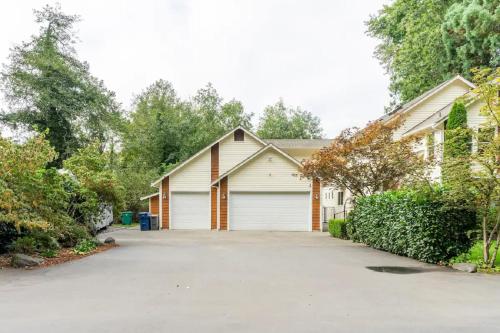 a house with a garage with a driveway at Private Waterfront Retreat near downtown Auburn in Auburn