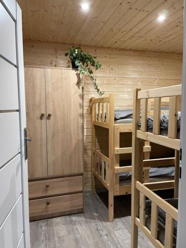 a room with two bunk beds and a closet at Domki Nad Sanem Bachórzec in Dubiecko