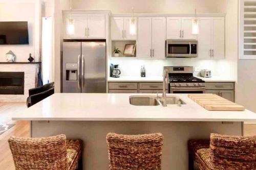 a kitchen with white cabinets and a kitchen island with chairs at Modern/ parking/Eden Park/near Downtown/ FCC in Cincinnati