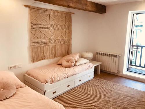 a bedroom with two beds and a table and a window at Casa La Marina in Hondarribia