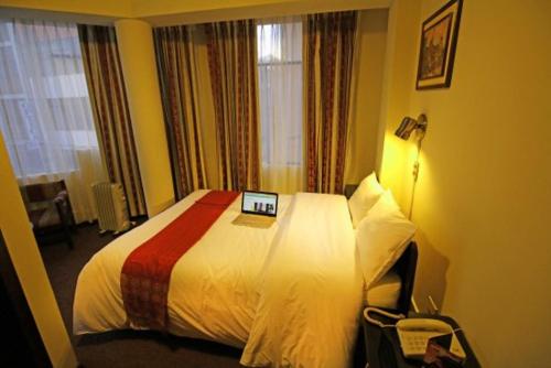 a hotel room with a bed with a laptop on it at Camino Real Puno in Puno