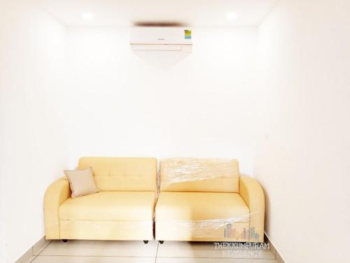 a yellow couch in a room with a white wall at THEKKUMPURAM RESIDENCY in Kondotti