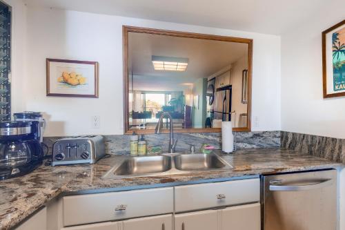 - un comptoir de cuisine avec un évier et un miroir dans l'établissement Hanalei Bay Resort 6222, à Princeville