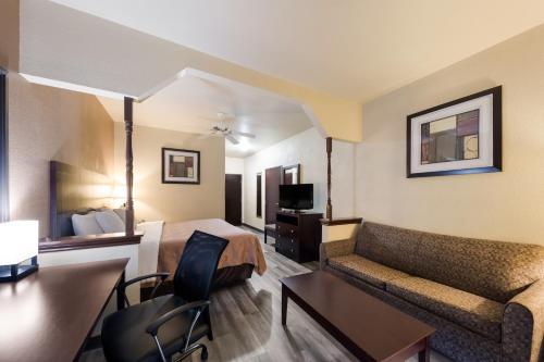 a hotel room with a bed and a couch at Quality Inn & Suites Terrell in Terrell