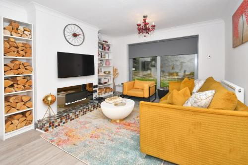 a living room with a yellow couch and a tv at Townhouse @ Aboyne Close Birmingham in Birmingham