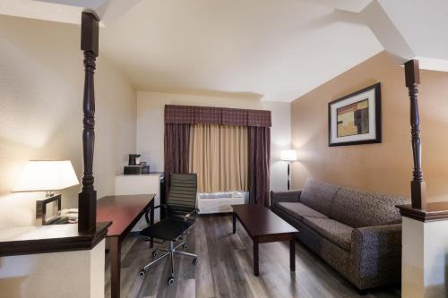a living room with a couch and a desk in a hotel room at Quality Inn & Suites Terrell in Terrell