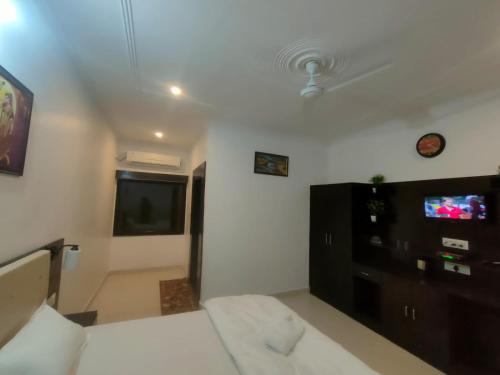 a bedroom with a bed and a flat screen tv at Hostel Arabian Night in Khajurāho