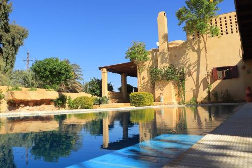 una piscina frente a una casa en Bequest, en Qaryat at Ta‘mīr as Siyāḩīyah