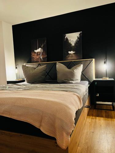 um quarto com uma cama grande e uma parede preta em Shadow Sleep em Schonungen