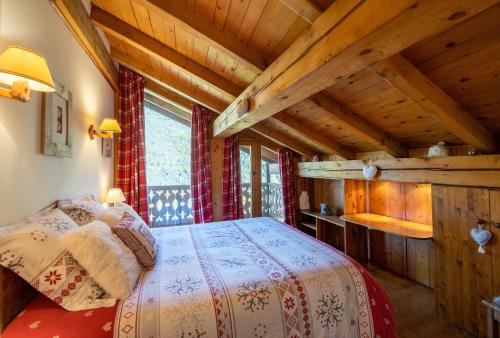 谷雪維爾的住宿－Magnifique chalet authentique au cœur des 3 vallées，一间带一张床的卧室,位于带木制天花板的房间内