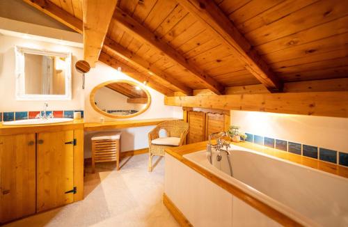 uma casa de banho com um lavatório e uma banheira num quarto em Magnifique chalet authentique au cœur des 3 vallées em Courchevel