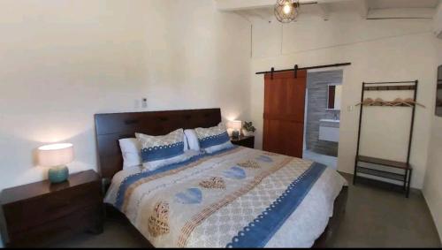 a bedroom with a large bed with blue and white sheets at Casita Amarilla in Santa Cruz