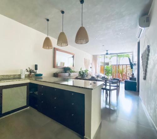 a kitchen with a counter and a dining room at Casa Azul 2 BedBath in Tulum