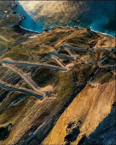an aerial view of a winding road on a mountain at Wooden House at the Mountain-private in Paránimfoi