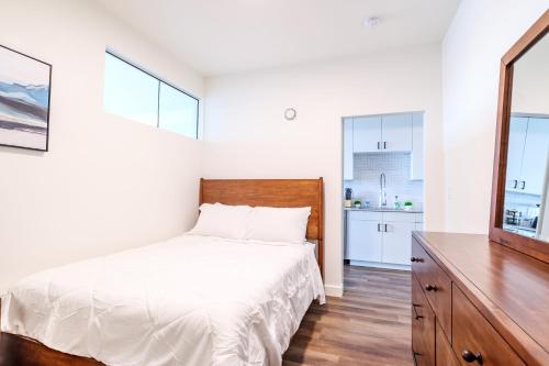 a bedroom with a bed and a dresser and two windows at Luxe Downtown Condo with Amenities 78 in Salt Lake City