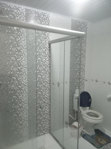 a bathroom with a toilet and a glass shower at Casa do scur in Canela