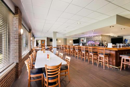 a dining room with tables and chairs and a bar at Best Western Grand Victorian Inn in Sayre