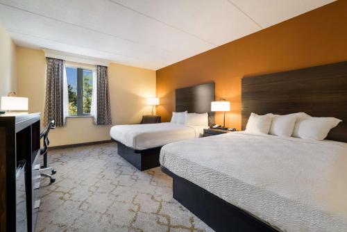 a hotel room with two beds and a television at Best Western Grand Victorian Inn in Sayre