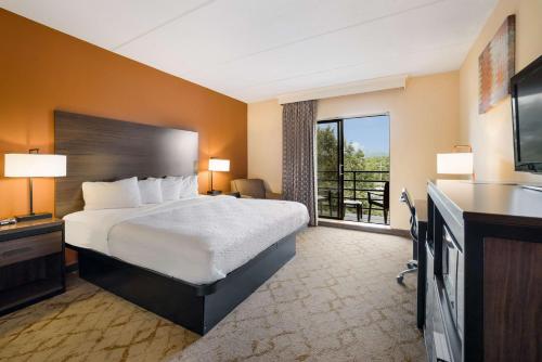 a hotel room with a bed and a large window at Best Western Grand Victorian Inn in Sayre