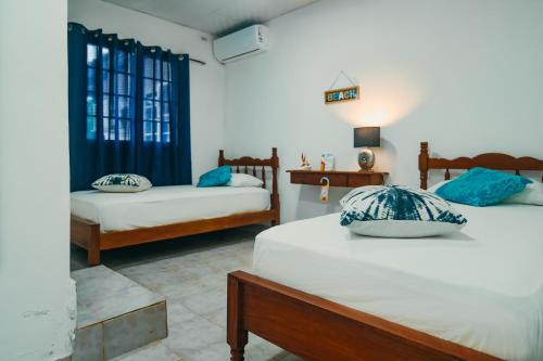 1 Schlafzimmer mit 2 Betten und blauen Kissen in der Unterkunft Sunset Catalina in Santa Catalina