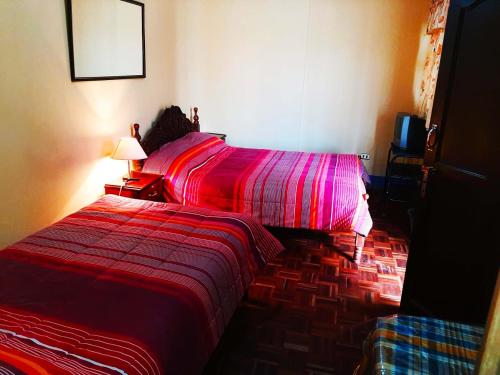 1 dormitorio con 1 cama con edredón rojo en Hostal Compañía de Jesús en Potosí