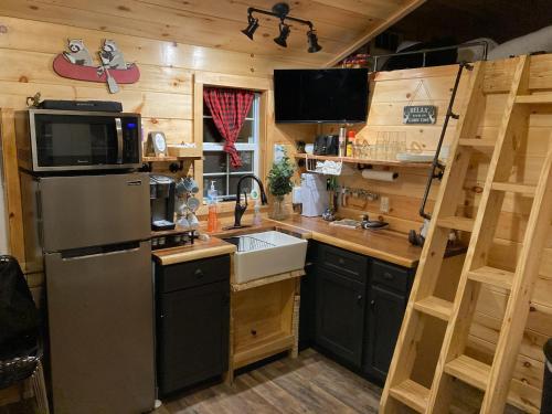 a kitchen with a refrigerator and a sink at Knotty Pines Cabin near Kentucky Lake, TN in Springville