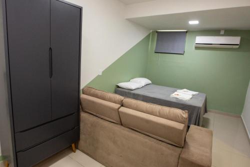 a small room with a bed and a couch at Jahu Center Plaza Flats in Jaú