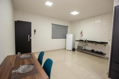 a dining room with a table and a refrigerator at Jahu Center Plaza Flats in Jaú
